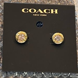 Gorgeous NWT COACH open circle pink stone stud earrings encased in gold metal.